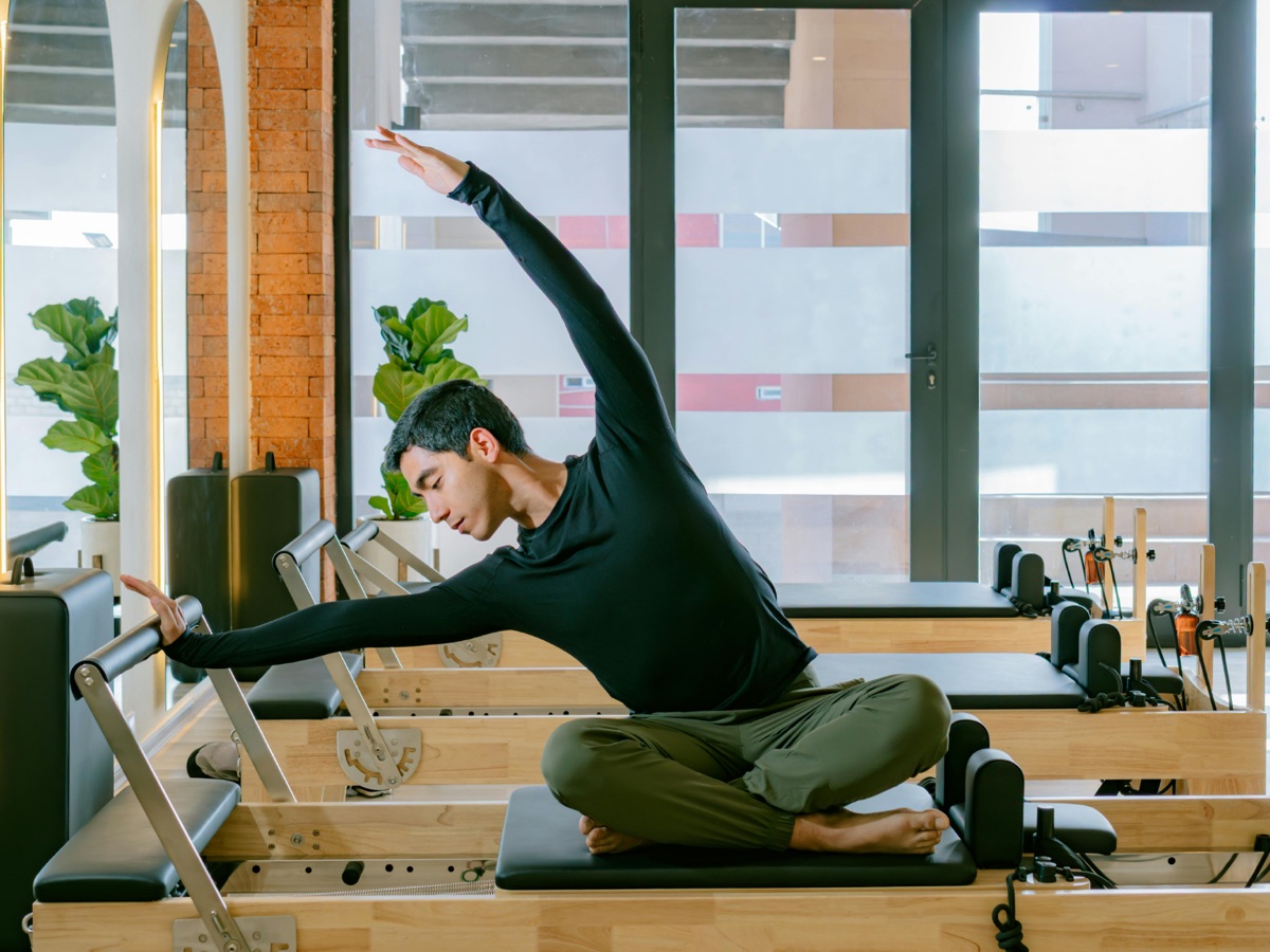 Mann bei einer Pilates-Übung am Reformer in einem Pilatesstudio in Deutschland, Inhaltsversicherung für Studio-Equipment in Pilatesstudios und Fitnessstudios, Sibel Lang Consulting
