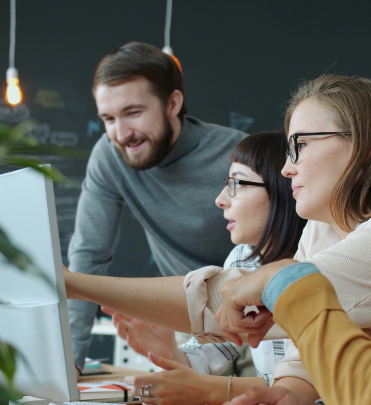 Team blickt gemeinsam auf einen Bildschirm, Mitarbeiterbindung und Absicherung mit Sibel Lang Consulting